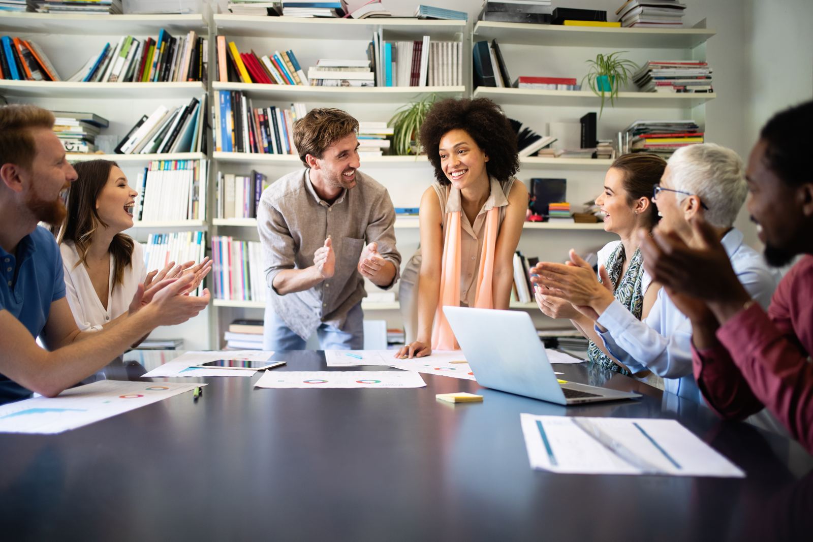 Collega's in gesprek rond een tafel met laptops