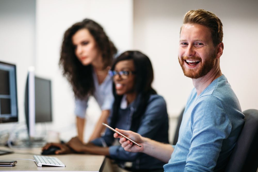 Een adviseur en collega's kijken samen naar een scherm
